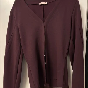 Vinröd kofta med v-ringning från Nelly - Vinröd populär cardigan från Nelly. Endast använd 2 gånger så är i väldigt bra skick!💕