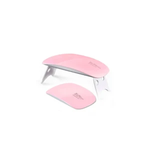 SUNmini UV/LED Nail Lamp - Kompakt och portabel UV/LED nagellampa i rosa, perfekt för gelnaglar. Lampan har vikbara ben och flera LED-lampor för effektiv härdning. Produkten ser ut att vara i nyskick utan synligt slitage eller defekter. Enkel att använda och passar både hemma och på resan.