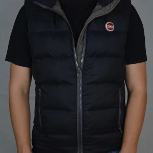 Colmar Väst - Svart dunväst från Colmar som är riktigt varm, Västen är i storlek M och är i bra skick, förutom att loggan är lite sprucken.                                     Vid frågor eller funderingar är det bara att höra av sig, och kom ihåg, alltid 14 dagars ångerrätt hos oss på Revalo!