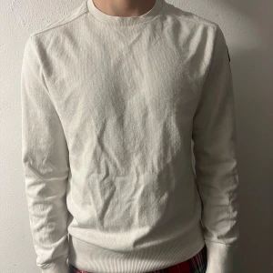 Vit fleece-tröja från Parajumpers - Säljer en stilren vit tröja från Parajumpers i storlek M. Tröjan har rund hals, ribbade muddar och ett snyggt patch på vänster ärm. Väldigt fint skick.