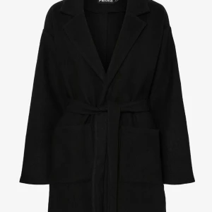 Svart kappa med bälte från Pieces - Stilren svart kappa från Pieces med klassisk krage och knytskärp i midjan. Jackan har stora fickor framtill och är tillverkad i ett mjukt material som känns lyxigt. Perfekt för dig som gillar en clean och enkel look.