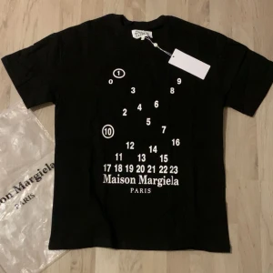 Maison Margiela t-shirt - En riktigt fet t shirt som är helt ny. Materialet är i bomull med bra kvalité. Den är till dig som vill ha en ut stickande t shirt. Påse och tag medföljs.