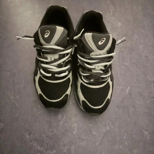 Asics Gel Nyc - Riktigt snygga Asics Gel Nyc skor i svart och grå, använt 2 gånger,extra snöret kan tas bort vid köp om det skulle önskas!!!,pris kan diskuteras !!