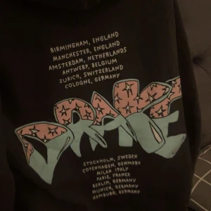 Svart Drake hoodie - Köpt på konserten. Svart hoodie från Drake med färgglatt graffiti-tryck både fram och bak. 