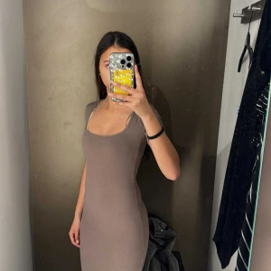 Beige ribbad långklänning - Säljer en beige, ribbad långklänning med tight passform och korta ärmar. Klänningen har en snygg fyrkantig urringning och är gjord i ett stretchigt material som sitter skönt mot kroppen. Köptes på newyorker och den har använts 1 gång. Ingen slits o den passar mig hela vägen ner till fötterna o jag är 1,60🥹skriv gärna för fler bilder❤️