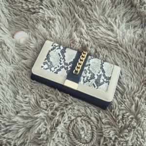 Kuvertväska med ormmönster och guldkedja - Snygg handväska i svart och beige med ormmönstrad framsida och guldfärgad kedjedetalj. Väskan är helt oanvånd och har dragkedja och stängs med tryckknapp. Skitsnygg för utekvällar och fester ❣️❣️ säljer då jag är silver tjej 🙃 ⚠️PRIS KAN ALLTID DISKUTERAS⚠️