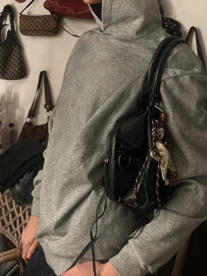 Grå hoodie från Acne Studios - Säljer en grå hoodie från Acne Studios med tryck på ryggen där det står 'Acne Studios STOCKHOLM 1996'. Hoodien har en klassisk huva och är gjord i mjukt material, perfekt för en avslappnad och stilren look.