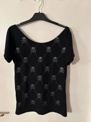 Topp från Lucyfer i storlek L. - Helt ny topp i stretchig viskostrikå. Storlek L.