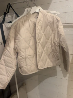 Beige pufferjacka från Ellos XS - Snygg beige jacka från hm i storlek XS. Jackan har ett quiltat mönster, super fin alldrig andvänd alla lappar kvar
