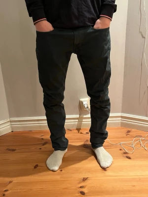 Replay jeans - Säljer ett par svarta jeansbyxor från Replay. Byxorna har klassisk femficksdesign och är tillverkade i ett mjukt bomullsmaterial. Snyggt snitt som sitter tajt över låren och smalnar av mot anklarna. Perfekta för dig som gillar stilrena och enkla jeans.