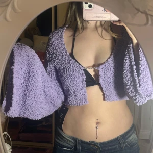 Ljuslila croppad bolero / topp NA-KD - Säljer en fluffig ljuslila bolerotopp med långärmade, vida ärmar och croppad passform från NA-KD. Öppen front med metalldetalj. Endast provad💛💛 Storlek XXS men den sitter löst så passar nog de flesta storlekar, jag är en S💛