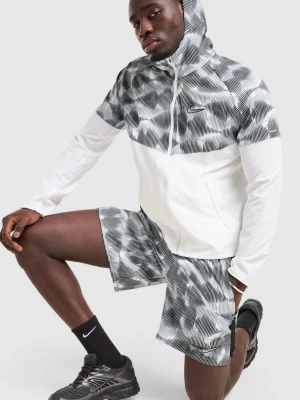 Nike träningsset med mönster - Snyggt träningsset från Nike med vit och gråmönstrad hoodie och matchande shorts. Jackan har dragkedja och huva, och båda plaggen har ett modernt grafiskt mönster. Perfekt för träning eller sportiga dagar.