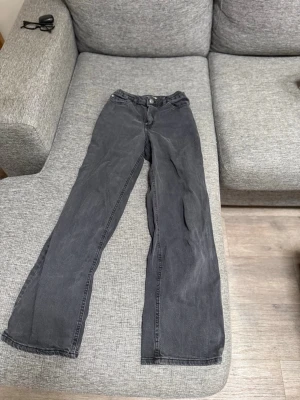 Svarta raka jeans med hög midja - Säljer ett par svarta jeans med rak passform och hög midja. Jeansen har klassisk femficksdesign och stängs med knapp och dragkedja. De är ifrån Lindex i storlek 152 och är i bra skick.