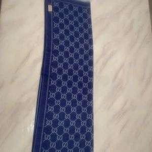 Blå halsduk från Gucci med GG-mönster - Supersnygg och i riktigt fint skick! Mjuk, lyxig och perfekt nu när det börjar bli kallare. Gucci lappen sömmen har har gått ut men man kan fixa det enkelt och man ser inte de.  Mått: 48 × 180 cm Kommer med äkta lappar och detaljer (se bilder).  💸 Ordinarie pris i butik: ca 3 500–4 000 kr 🔥 Mitt pris: skriv dm!  Passar både tjejer och killar.  📩 Skriv dm vid intresse!