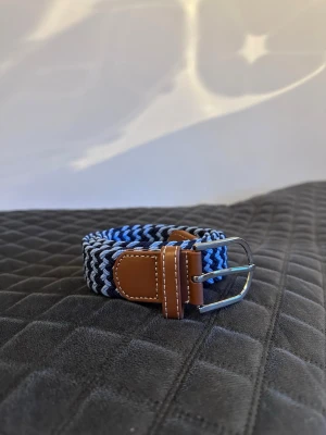 Blått flätat bälte - Tja det är helt nytt från bältgallerian i storlek 105cm långt och 3,5cm brett. Det är gjort i ett elastiskt material och man kan anpassa längden vart man än vill. Om du inte gillar den här färgen finns flera andra att välja mellan. Desto mer du köper desto billigare blir det. Säljer också armband.