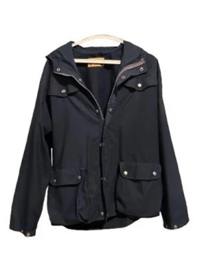 Mörkblå Fjällräven jacka - Stilren mörkblå parkasjacka med huva och stora fickor framtill. Jackan har dragkedja och tryckknappar, samt justerbar nederkant. Perfekt för kyliga dagar och enkel att matcha med olika outfits.