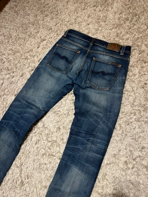 Nudie jeans grim tim slim fit herr fade wash w31 L32  - Nudie jeans modell grim tim. Slim fit med en riktigt fet fade och snygga whiskers. Mycket bra skick, inga märkvärdiga defekter. Storlek W31 L32. Postas samma dag slm köp eller dagen därpå🙌💯