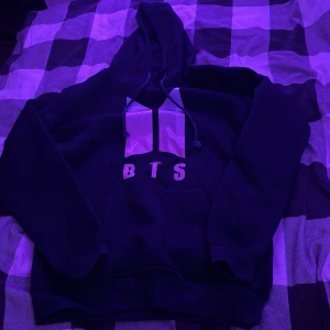 Svart BTS hoodie Love Yourself S - Svart hoodie med BTS-logga och texten 'Love Yourself Her' på ryggen. Tröjan har huva med snörning och stor magficka framtill. Perfekt för dig som är ARMY och vill visa din kärlek till BTS. Mjuk insida och klassisk passform.