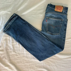 Levi's 551Z Straight blå jeans - Säljer ett par Levi's 551Z Authentic Straight jeans i klassisk blå tvätt. Modellen har raka ben, fem fickor och den ikoniska Levi's-lappen bak i midjan. Jeansen är tillverkade i slitstarkt denim med snygga kontrastsömmar och röd Levi's-tag vid bakfickan.