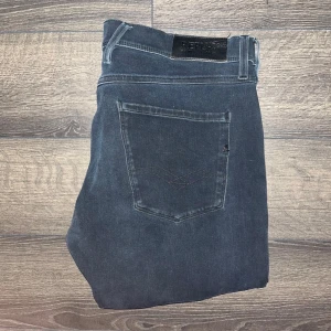 Replay Anbass hyperflex  - Snygga mörkblå Replay Anbass hyperflex jeans i klassisk femficksmodell. Jeansen har smal passform och raka ben, med diskreta slitningar och svarta detaljer på bakfickan. Tillverkade i stretchig bomullsdenim för extra komfort. Midja 44cm, längd 100cm. JAG SKICKAR INGA FLER BILDER PÅ NÄR JAG BÄR PLAGGET :)s2