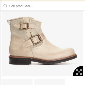 Skor - Snygga låga MC-boots i beige nubuck och canvas från The Urban Project. Skorna har dekorativa spännen i antik mässinglook, dragkedja på insidan och skinnfoder med uttagbar innersula. Perfekt för dig som gillar en tuff men feminin stil. nypris 1700 kr använda en gång från scorett 