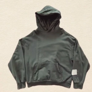 Mörkgrön hoodie med huva - En stilren mörkgrön hoodie med huva och magficka. Tröjan har långa ärmar, ribbade muddar och en relaxed passform. Perfekt för dig som gillar en enkel och clean look.