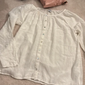 Vit långärmad skjorta Saint Tropez - Vit, tunn och flowy skjorta från Saint Tropez i storlek S. Skjortan har lång ärm, rund halsringning och knappar hela vägen framtill. Materialet är lätt och känns luftigt. Lägger ett billigt pris💕💕