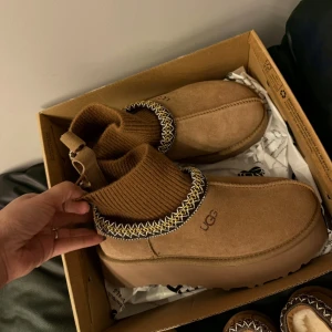 UGG platform boots i olika färger - UGG boots med chunky plattformsula i mocka, finns i beige, brun, ljusbrun och rosa. Dekorativt broderi runt öppningen och vissa modeller har ribbstickad mudd. Perfekta för kalla dagar med sin mysiga insida och coola look.