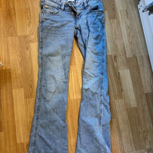 Bootcut jeans med broderi Lager157 - Ljusblå bootcut jeans från 157 i storlek XS. Snygga broderade detaljer i guld på bakfickorna och bälteshällor. Klassisk femficksmodell i mjukt denimtyg med dragkedja och knapp framtill. Perfekta för dig som gillar en avslappnad men ändå unik stil.