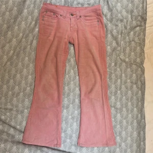 Lågmidjade rosa manchesterbyxor - Säljer de här assnygga lågmidjade byxorna då de tyvärr är för kort för mig (är 165 och de är ca 6/7 cm för korta. Jättefin rosa färg. Midjemåttet är 38cm och innerbenslängden är 70 cm