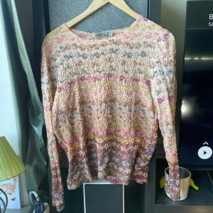 Blommig långärmad blus från KRISS - Superfin blus från KRISS i storlek M med blommigt mönster i pastelliga färger som rosa, gul, grön och blå. Tunn och luftig med lång ärm och rund halsringning. Perfekt för dig som gillar färg och mönster!