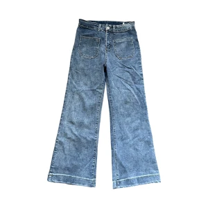Blåa wide jeans - Snygga blå jeans med breda ben och hög midja. Klassisk femficksmodell med fram- och bakfickor samt markerade sömmar längst ner på benen. Perfekta för en avslappnad och trendig look.