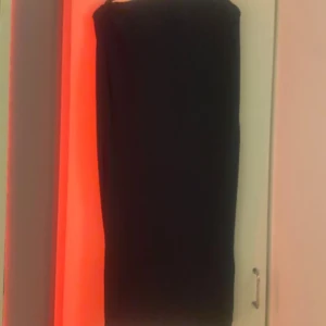 Svart långkjol från 157 - Enkel svart långkjol från 157 med rak passform och resår i midjan. Kjolen är enfärgad och har en stilren look som är lätt att matcha. Perfekt för dig som gillar minimalistisk stil och vill ha något bekvämt och snyggt. har en liten fläck på dig som går bort i tvätten