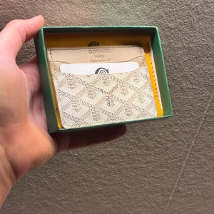 Vit korthållare  - Snygg vit korthållare med ikoniskt mönster och flera kortfack. Tillverkad i skinn material och  Perfekt för dig som vill ha något både stilrent och unikt i fickan.