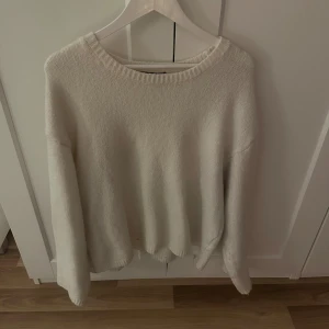 Vit stickad tröja från BikBok - Mysig vit stickad tröja från BikBok i storlek L. Tröjan har en klassisk rund halsringning och långa ärmar. Perfekt för lager-på-lager och chill dagar. Enkel och stilren design som funkar till allt. Stor i storleken, passar även XL. 