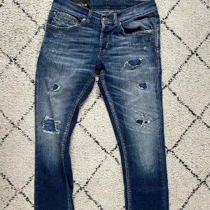 Blå slitna jeans med hål - Snygga blå jeans från Dondup med slitningar. Väldigt bra färg enligt mig nyare modell nypris:3200 mitt pris:999 men ta även emot bud om det passar mig i pris hör av er om ni har några frågor eller funderingar storlek: W30