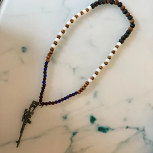 Halsband med pärlor - Unikt halsband med små pärlor i vitt, brunt, blått och svart. 