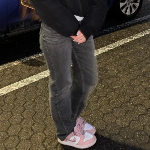 Grå raka jeans - Säljer ett par grå jeans med rak passform och klassisk femficksdesign. Jeansen har en avslappnad look och är perfekta för dig som gillar en enkel och stilren vibe. Materialet är jeans och färgen är en snygg mörkgrå ton.