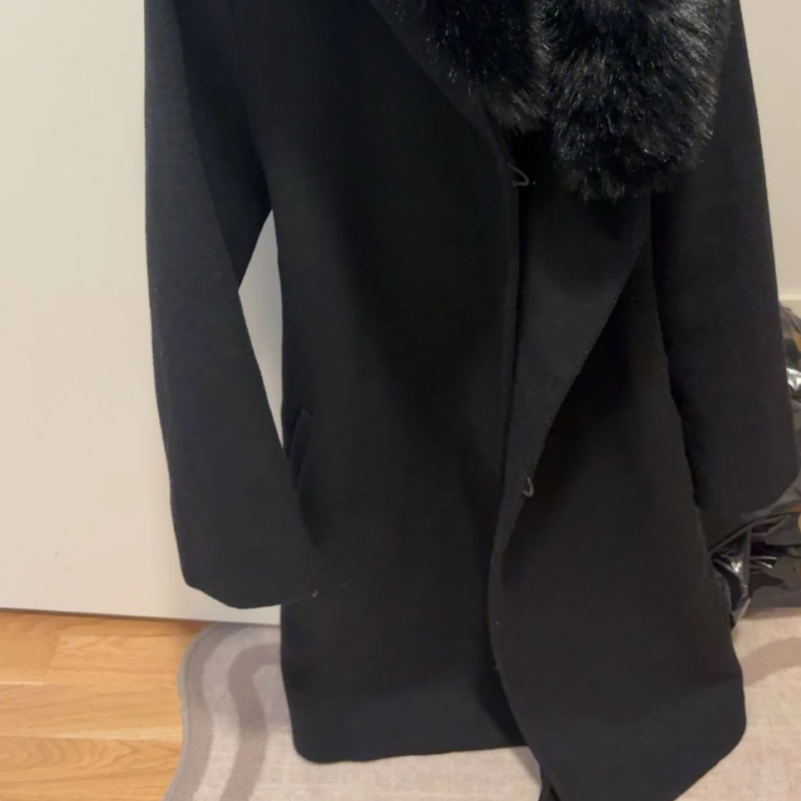 Svart kappa med pälsdetalj