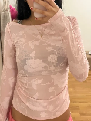 Ljusrosa blommig topp - Säljer en ljusrosa långärmad topp från Gina, den är lite genomskinlig. har bara använt den 1 gång