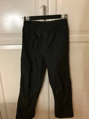 Svarta täckbyxor från Everest - Svarta täckbyxor från Everest med elastisk midja och meshfoder. Byxorna har raka ben och reflekterande detaljer vid benslutet. Perfekta för kalla dagar och utomhusaktiviteter. Snygg och enkel design som funkar till allt. Köp nu jag postar snabbt!!💕💕