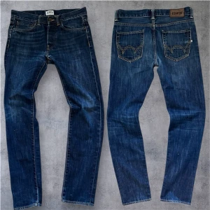 Vintage Edwin japan jeans  - Snygga Edwin ED-80 jeans i slim fit med klassisk femficksdesign och coola kontrastsömmar. Färgen är mörkblå med lätt tvättad look och detaljerade bakfickor. Perfekt passform för dig som gillar smalare jeans.