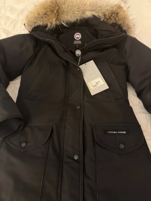 Canada goose jacka - Äkta canadagoose jacka i modellen trillium parka strl xs. Köpte den från johnells och den är ganska använd, .Den har  lite missfärgade fläckar på vissa ställen som ni ser på första bilden. Annars är den i bra skick och den har inga hål eller andra super tydliga defekter. Värmer sååå himla bra!!. Har bild på kvittot ifall ni är intresserade. 