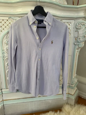 Ralph Lauren skjorta - Säljer en blå Ralph Lauren skjorta i mycket bra skick! 💸 Nypris: ca 2000 kr 🚚 Snabb frakt! Skickas inom 1–2 dagar ✅ Inga fläckar, hål eller synliga tecken på slitage.   💬 Skriv gärna vid frågor – jag svarar snabbt!
