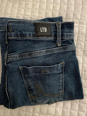 Blå bootcut jeans från LTB - (Lånade bilder av hon jag köpte av) Snygga blå jeans från LTB, modell FALLON, storlek W26 och L36. Jeansen är mörkblåa och bootcut och är perfekta för alla årstider. Oanvända och säljer då jag tyvärr köpte fel modell. 