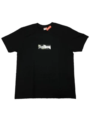 Supreme svart t-shirt med camo-logga - Supreme t-shirt i svart med klassisk box logo på bröstet i camouflage-mönster. Storlek M, 73 cm i längd, aldrig använd. 