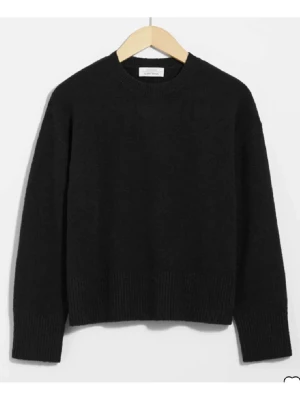 Svart stickad tröja från & Other Stories - En stilren svart stickad tröja från & Other Stories med rund hals och ribbade muddar vid ärmslut och nederkant. Perfekt för lager-på-lager och passar till både jeans och kjol. Tröjan har en normal passform och långa ärmar.