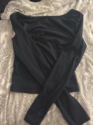 Svart långärmad topp med bred ringning - En enkel och stilren svart långärmad topp från gina young. Toppen är i ett mjukt och stretchigt material som sitter skönt mot kroppen. Perfekt att matcha med jeans eller kjol för en clean look. Passar mig med storlek xs