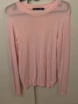 Ljusrosa stickad tröja från 157 (inte använd)  - Säljer en ljusrosa stickad tröja från 157 i storlek XS. Tröjan har rundad hals, ribbade muddar och är långärmad. Materialet är tunt och mjukt, perfekt för lager-på-lager. Enkel och stilren design som funkar till många olika looks.