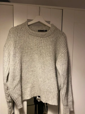 Ljusgrå stickad tröja från 157 - Säljer en ljusgrå stickad tröja från 157 i storlek M. Tröjan har grovstickad struktur, rund hals och långa ärmar med ribbade muddar. Använd en del men ingen tydlig defekt.🫶🏼